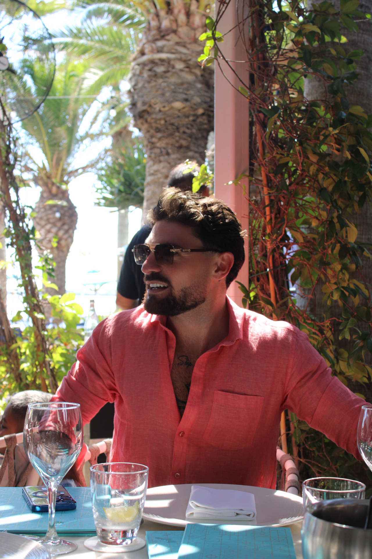 Arsen Dimitriou at a restaurant table among palm trees